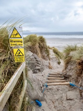 Signs warning of Sudden Drop and Steep Slope at Dooey beach by Lettermacaward in County Donegal - Ireland clipart