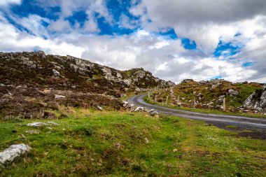 The beautiful rocks next to the scenic coastal single track road between Meenacross and Crohy Head south of Dungloe, County Donegal - Ireland. clipart