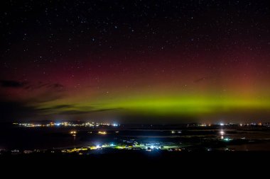 The Aurora Borealis, the northern lights, showing up above Maghery, Burtonport, Arranmore and Dungloe in County Donegal, Ireland clipart