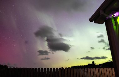 The Aurora Borealis, the northern lights, showing up above bungalow in County Donegal, Ireland. clipart