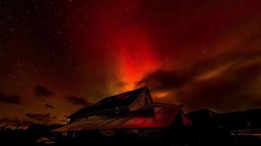 Kuzey ışıkları Aurora Borealis 'in yanından geçen Yıldız Bağlantısı uyduları İrlanda' nın Donegal ilçesindeki bungalovun üzerinde beliriyor..