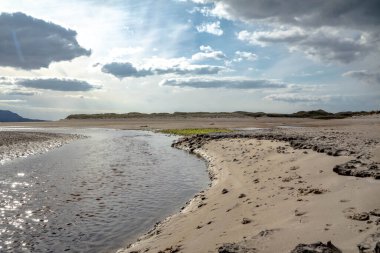 The stream that flows from Sheskinmore Nature Reserve to Ballinravey Strand between Ardara and Portnoo in Donegal - Ireland. clipart