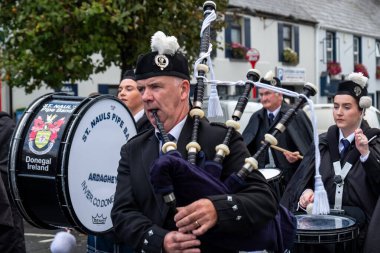GLENTIES, COUNTY DONEGAL, IRELAND - 14 Eylül 2025: St. Nauls Pipes and Drums ana caddedeki ücretsiz Glenties Hasat Fuarı 'nda sahne alıyor.