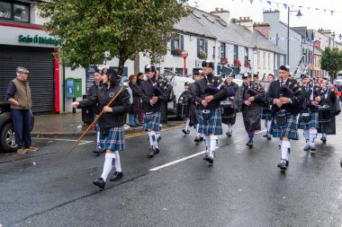 GLENTIES, COUNTY DONEGAL, IRELAND - 14 Eylül 2025: St. Nauls Pipes and Drums ana caddedeki ücretsiz Glenties Hasat Fuarı 'nda sahne alıyor.
