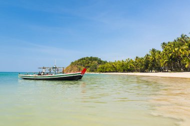 Ngapal 'ın güzel plajları. Denizin üzerinde balıkçı tekneleri ve palmiyeler asılı, Myanmar.