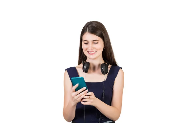 一个正面的年轻女人 脖子上戴着耳机 满意地看着她的手机 被白色背景隔离着 — 图库照片