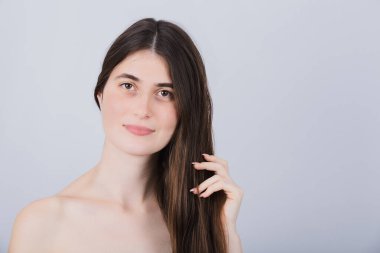 Kameraya gülümseyen uzun düz saçlı güzel model kız. Saç bakımı ve spa tedavisi konsepti.