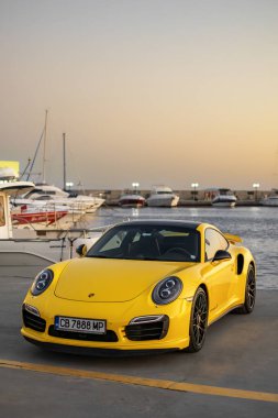Sarı Porsche 911 Turbo S gün batımında