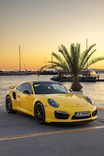 Sarı Porsche 911 Turbo S gün batımında
