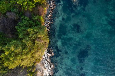 Gün batımında güzel bir kayalık sahile doğru hava manzarası.