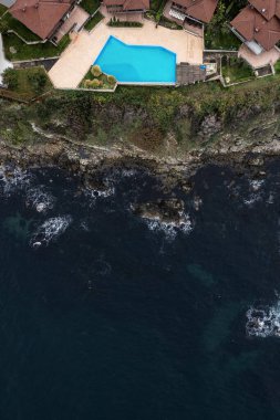 Bulgaristan 'ın Sozopol kentinde deniz kıyısındaki uçurum kenarındaki evlerin havadan görüntüsü