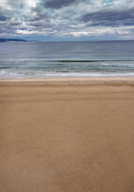 Kumsala hava manzarası, sakin deniz ve bulutlu gökyüzü