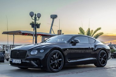 Marina Dinevi, Sveti Vlas, Burgaz, Bulgaristan - 17 Ağustos 2024, Black Bentley yat marinasında gün batımında parkedildi