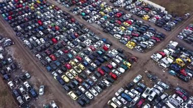 Araba hurdalığının hava görüntüsü sökülmek için terk edilmiş araçların sıralarını gösteriyor