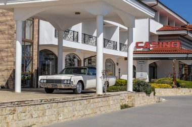 Marina Dinevi, Sveti Vlas, Burgaz, Bulgaristan - 04.21.2025. Lüks beyaz 1963 Lincoln Continental Sedan Sveti Vlas, Burgaz, Bulgaristan 'da yat marinasında bir otelin önünde bekliyor.