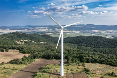 Tepedeki rüzgar parkındaki rüzgar türbininin pervane kanatlarına hava görüntüsü