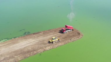 Bulgaristan 'ın Burgaz bölgesinin Meden Rudnik ilçesi yakınlarındaki yeşil sularda yol yapımında çalışan buldozer ve çöp kamyonunun hava manzarası