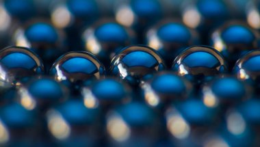 Mavi ışıkla parlayan küçük metal küre. Makro fotoğraf, soyut arkaplan