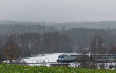 Tren kışın Çek topraklarında sisli ve kasvetli havada raylarda ilerliyor. Ulaşım kavramı