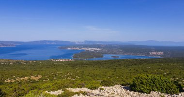 Punat körfezi Veli Vrh tepesinin altında gözcülük yapıyor. Hırvatistan doğası, Krk adası 