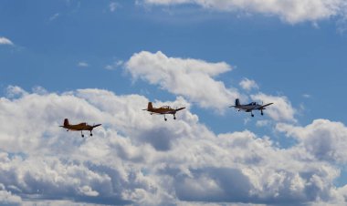 Bulutlu gökyüzünde üç akrobatik uçak yan yana uçuyor. Havacılık, spor geçmişi