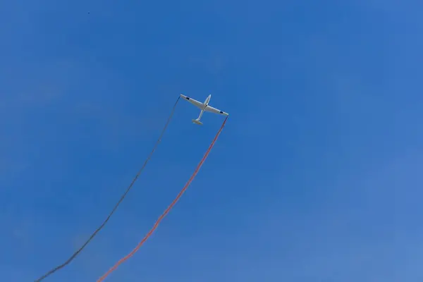 滑翔机在蓝天上飞行时 双翼冒烟 休闲体育背景 — 图库照片