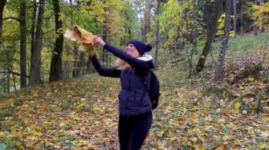 Güz yaprağıyla etrafında dönen güzel genç kadın, sonbahar mevsiminin tadını çıkar. Gülümseyen mutlu insanlar, Çek manzarası, yavaş çekim