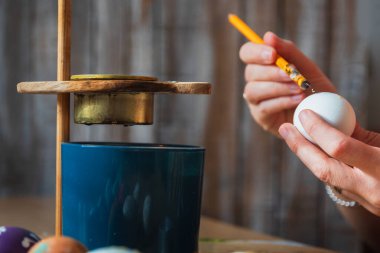 Paskalya yumurtasını mumla boyayan kadın. Geleneksel tatil alışkanlığı, yaşam tarzı