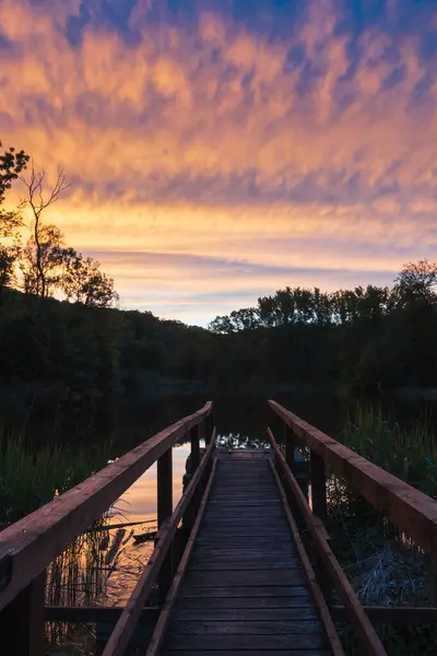 stock image Wooden bridge on pond water gate with dramatic sunset sky. Czech, ceske stredohori nature background 