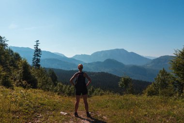 Kadın, Avusturya Alp dağının tepesinde sırt çantalı bir yürüyüşçü var. Etkin tatil kavramı geçmişi 