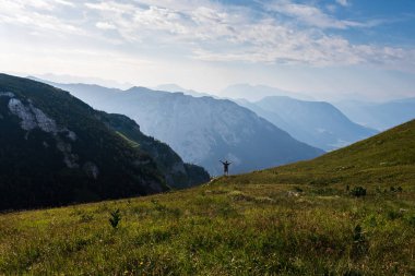 Sırt çantalı ve elleri dağ vadisinde duran bir turist. Kaybeden, Avusturya Alpleri