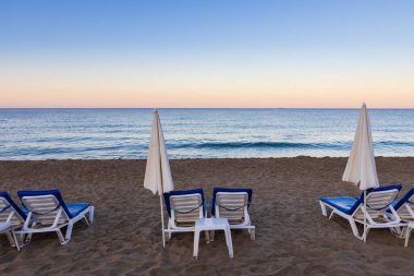 Güneş şemsiyesi ve şezlong kumsalda, Kleopatra plajında sabah denizi, Alanya  
