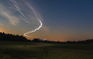 Geceleri gökyüzü yıldızıyla çayırda koşan bir adamın hafif izleri. Çek manzarası