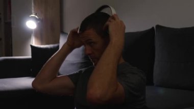 Genç adam kulaklıkları al ve kapalı gözlerle müzik dinle. Rahatla, yaşam tarzı boş zaman aktivitesi, yakın çekim