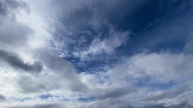 Beyaz kümülüs ve sirrus bulutları mavi gökyüzünde akıyor. Doğa, hava, hava akımı geçmişi