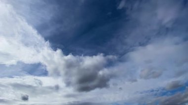 Beyaz kümülüs ve sirrus bulutları mavi gökyüzünde akıyor. Doğa, hava, hava akımı geçmişi
