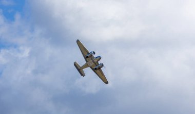 Çelik çift kanatlı uçak bulutlu gökyüzünde geriye doğru ulaşım uçağı