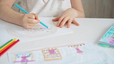 Bir çocuğun parlak kalemlerle çizdiği bir çizime yakından bakın. Genç kız renkli sanatsal çizimler yapıyor ve kalem kullanarak renk etkinliği yapıyor. Yaratıcılığı arttırmak. Hayal gücü.