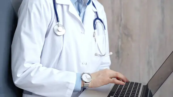 stock image Doctor at work. Unrecognizable medical professional using laptop computer for healthcare research showcasing modern medical technology, close up.