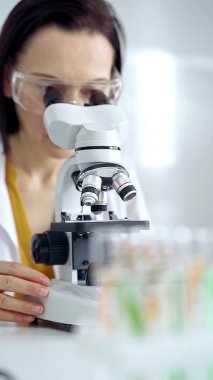 Laboratuvarda mikroskop kullanan kadın bilim adamı. Mikrobiyoloji bilim konsepti.