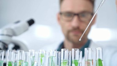 Güvenlik gözlüklü bir araştırmacı laboratuvar borularıyla laboratuvar ekipmanlarına yakın çekim yapıyor. Bilim ve tıp.