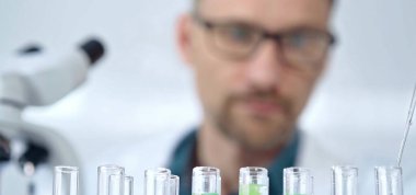 Güvenlik gözlüklü bir araştırmacı laboratuvar borularıyla laboratuvar ekipmanlarına yakın çekim yapıyor. Bilim ve tıp.