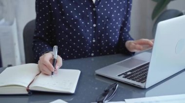 Modern bir iş yerindeki dizüstü bilgisayarın yanında profesyonel bir iş kadını yazısı, yakın görüş. İş konsepti.