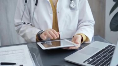 İşteki doktor. Klinikte tablet kullanan bir tıp uzmanı. İlaç ve sağlık hizmetleri kavramı.