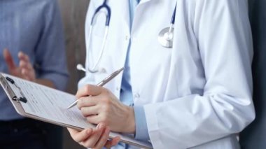Doktor, panoya tıbbi notlar yazarken hastaya dosyayla danışmanlık yapıyor. Tıp konsepti.