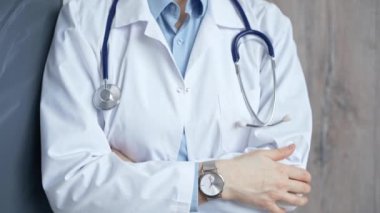 Kolları çaprazlanmış steteskoplu beyaz önlüklü profesyonel bir doktor. Tanınmayan kadın doktor hastalara yardım etmeye hazır. Tıp konsepti.