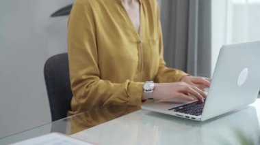 Genç profesyonel kadın modern ofiste dizüstü bilgisayarla çalışıyor. Sarı bluz yetişkin iş kadınına geçiyor. Başarı kavramına uçmak.