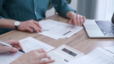 İş adamları finansal belgeleri inceliyor. İki meslektaş birlikte çalışıyor, kağıtları gözden geçiriyorlar ve dizüstü bilgisayar kullanıyorlar. Mali denetim ve vergiler
