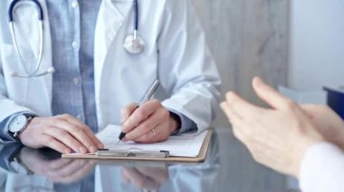 Not almak için bir pano kullanan bir doktora danışıyorum. Klinikteki tıp bürosu. Tıp konsepti.