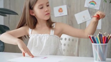 Genç kız renkli kalemleri seçiyor ve yaratıcı bir aktivite için renkli bir setten kalem seçiyor..